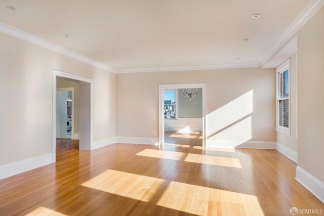 unfurnished room featuring light wood-type flooring and ornamental molding