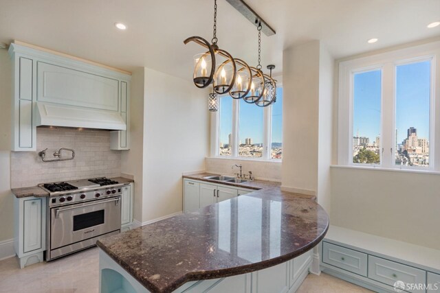 kitchen featuring pendant lighting, high end stainless steel range oven, a notable chandelier, kitchen peninsula, and custom exhaust hood