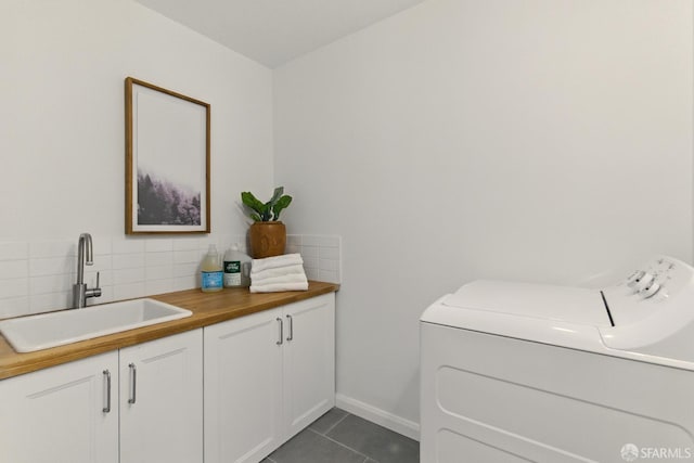 1278 La Playa St, San Francisco, CA 94122 - clothes washing area featuring washing machine and dryer, cabinet space, dark tile patterned flooring, and baseboards