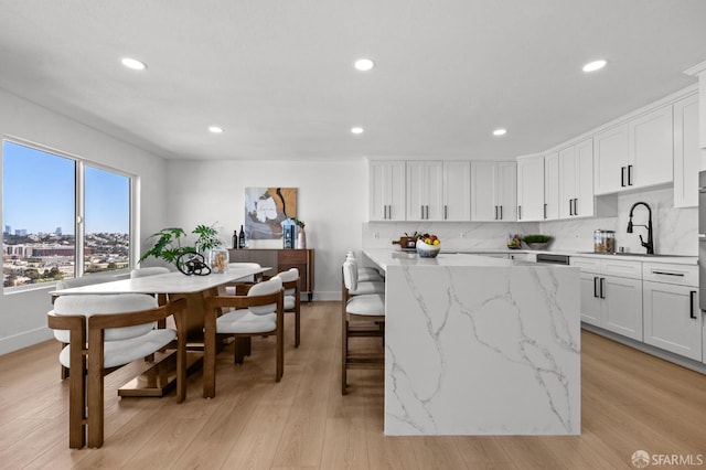 226 Rutledge St, San Francisco, CA 94110 - kitchen featuring recessed lighting, a center island, light wood finished floors, white cabinets, and light stone counters