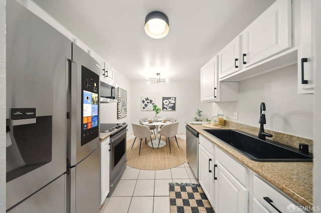 16006 E 14th St Unit 101, San Leandro, CA 94578 - kitchen with stainless steel appliances, a sink, white cabinetry, and light tile patterned floors