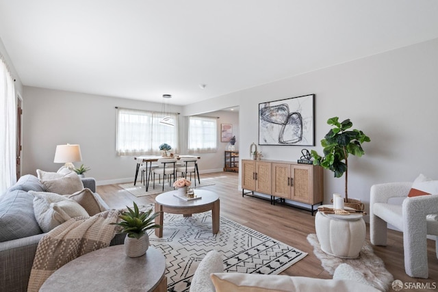 living area with light wood-type flooring and baseboards
