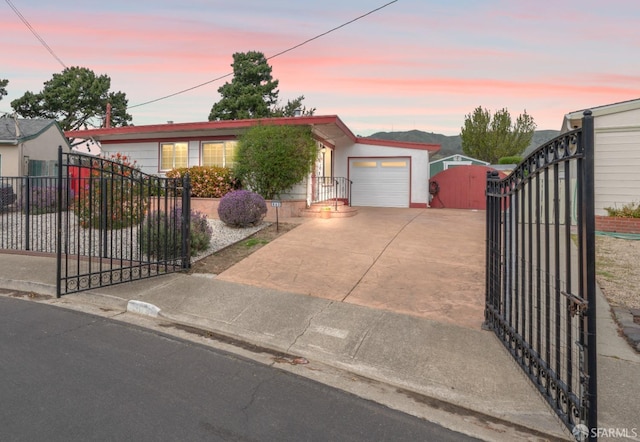 ranch-style home featuring an attached garage, fence, a gate, and concrete driveway