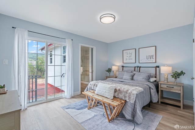 bedroom with light wood finished floors, access to outside, baseboards, and ensuite bathroom