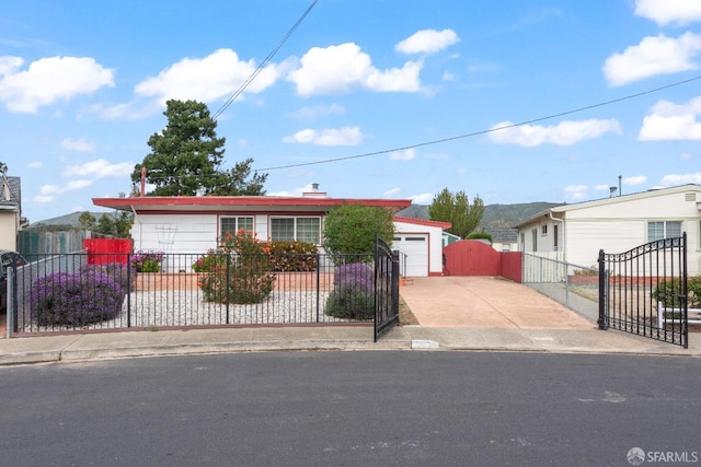 view of front of home with driveway, a fenced front yard, and a gate