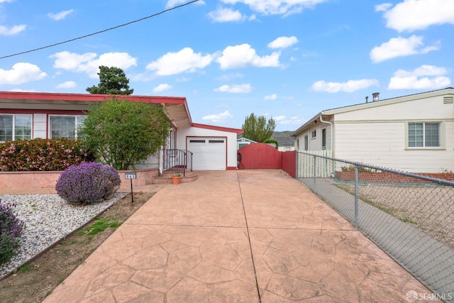 view of front of house with concrete driveway, fence, and a gate