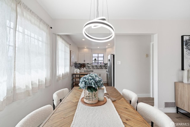 dining room featuring an inviting chandelier, baseboards, and visible vents