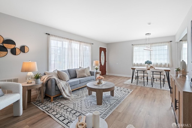 living room featuring baseboards and light wood-type flooring