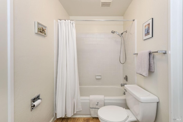 full bath featuring shower / bath combination with curtain, toilet, wood finished floors, and visible vents