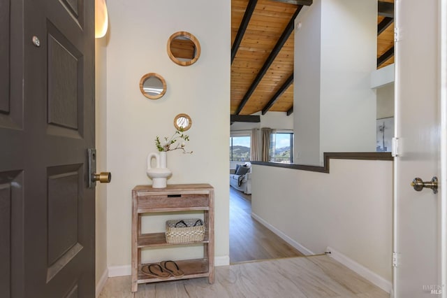 hallway featuring baseboards, wood finished floors, wooden ceiling, and vaulted ceiling with beams