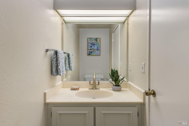 half bath featuring toilet and vanity