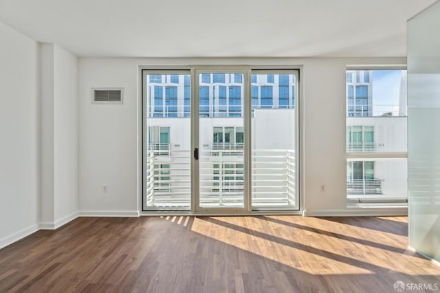 doorway featuring wood finished floors and baseboards