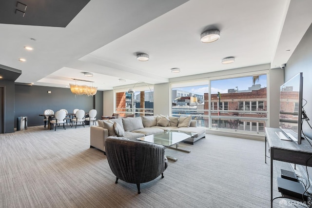 carpeted living room featuring a chandelier