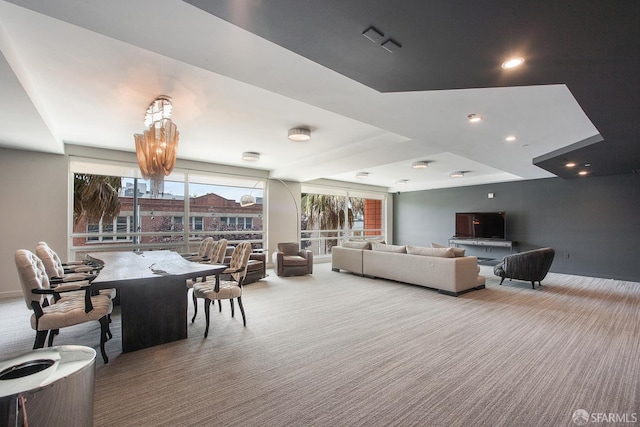 carpeted living room featuring a chandelier