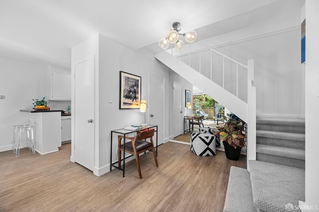 stairs featuring hardwood / wood-style flooring and an inviting chandelier