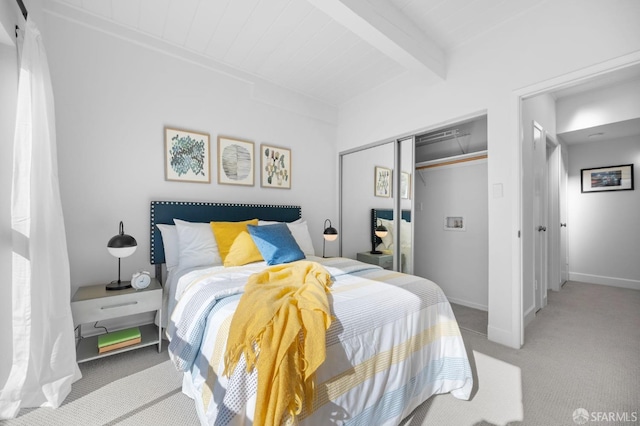 carpeted bedroom with a closet and beam ceiling