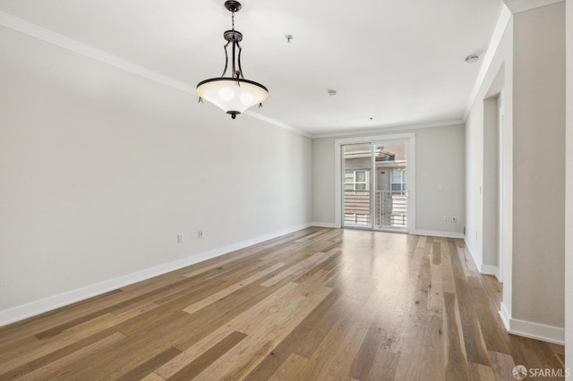 spare room with light wood-type flooring and ornamental molding