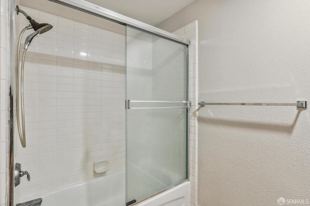 bathroom with combined bath / shower with glass door