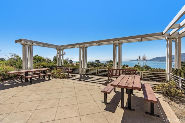 view of patio / terrace featuring a pergola and a water view