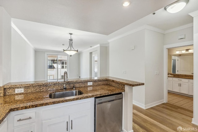 kitchen with white cabinetry, dishwasher, sink, dark stone countertops, and pendant lighting