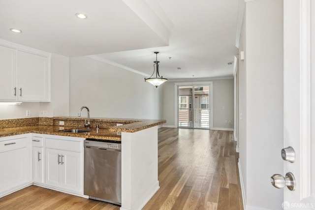 kitchen featuring dishwasher, sink, kitchen peninsula, dark stone countertops, and white cabinets