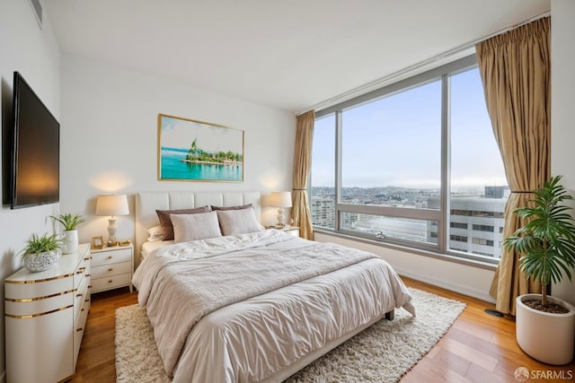 bedroom featuring multiple windows and light hardwood / wood-style flooring