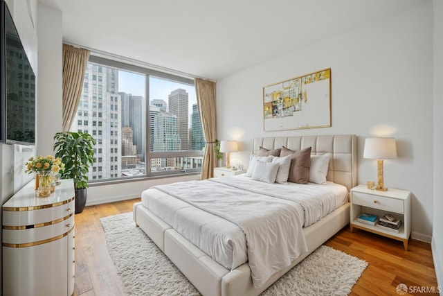 bedroom with light wood-type flooring and multiple windows