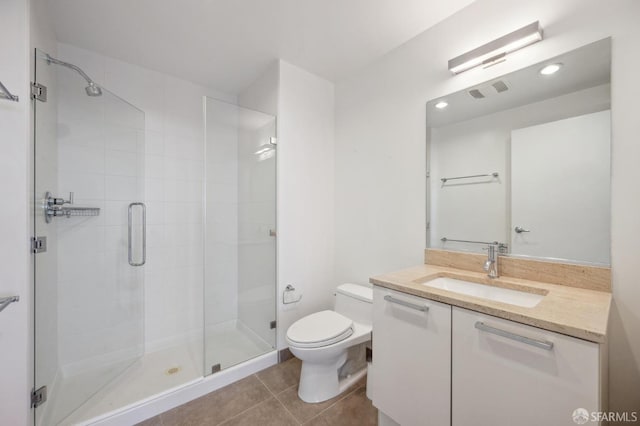 bathroom featuring tile patterned floors, toilet, vanity, and walk in shower