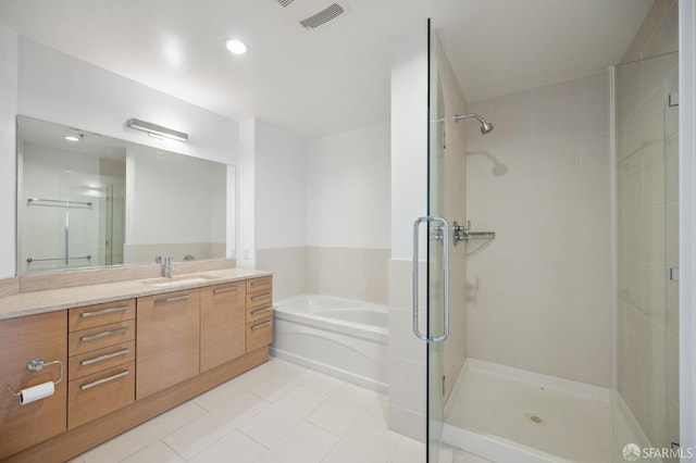 bathroom featuring vanity, independent shower and bath, and tile patterned floors