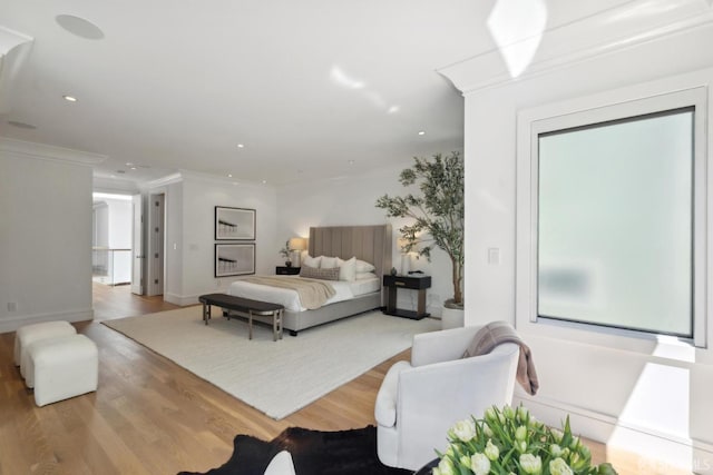 bedroom featuring wood finished floors, crown molding, recessed lighting, and baseboards