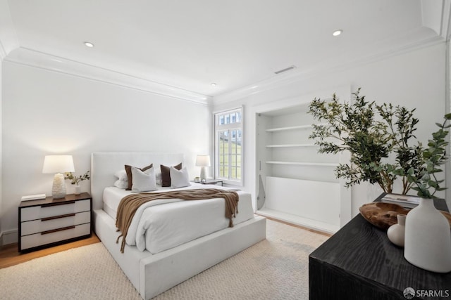bedroom with crown molding, wood finished floors, and recessed lighting