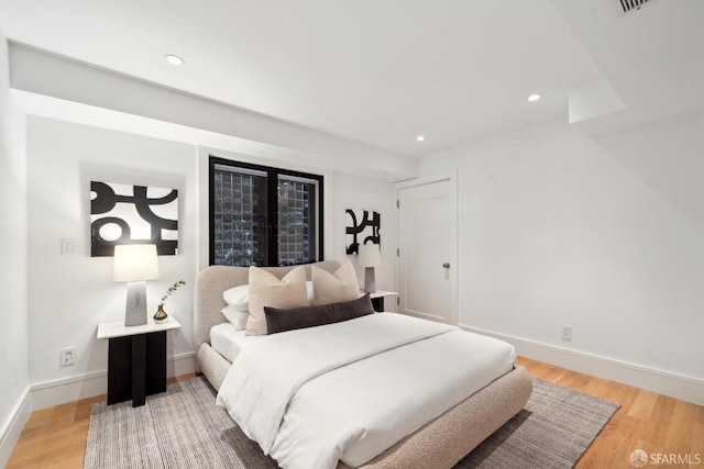bedroom featuring light wood finished floors, recessed lighting, and baseboards
