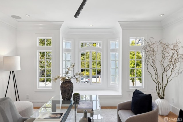 living area with plenty of natural light, wood finished floors, and crown molding