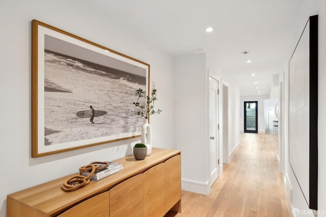 hall featuring light wood-style floors, recessed lighting, and baseboards