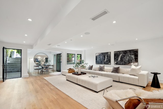 living area with recessed lighting, light wood finished floors, stairs, and baseboards