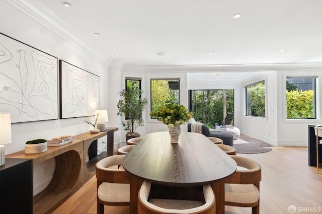 dining room with light wood-type flooring, crown molding, baseboards, and recessed lighting