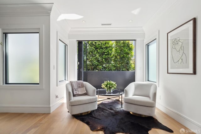 sitting room featuring crown molding, wood finished floors, and baseboards