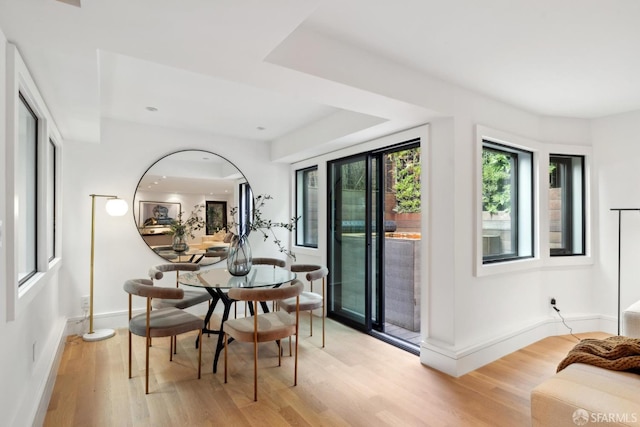 dining space featuring light wood-style flooring and baseboards