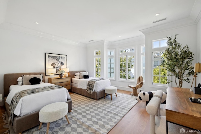 bedroom with wood finished floors, ornamental molding, and recessed lighting