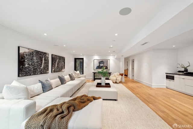 living room with light wood-style flooring, recessed lighting, and baseboards
