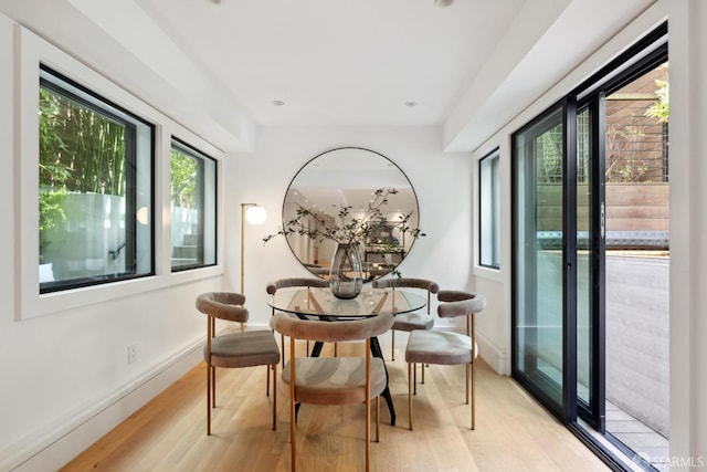 dining space featuring light wood-style flooring and baseboards