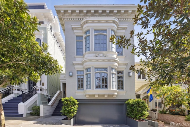 view of front facade with an attached garage and stairs