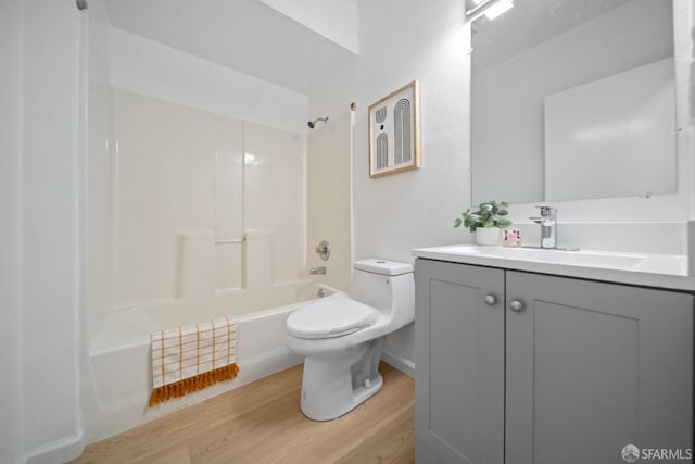 bathroom featuring toilet, vanity, shower / tub combination, and wood finished floors