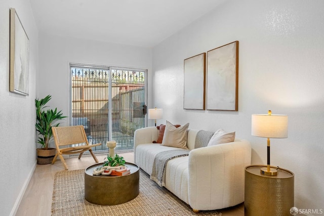 living area with light wood-type flooring and baseboards