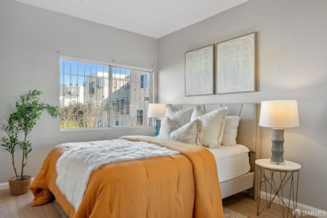 bedroom featuring baseboards and wood finished floors