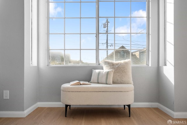 sitting room with baseboards and wood finished floors