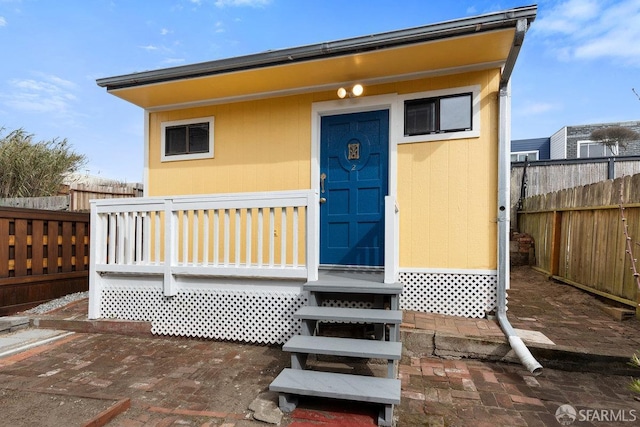 property entrance featuring fence and a deck