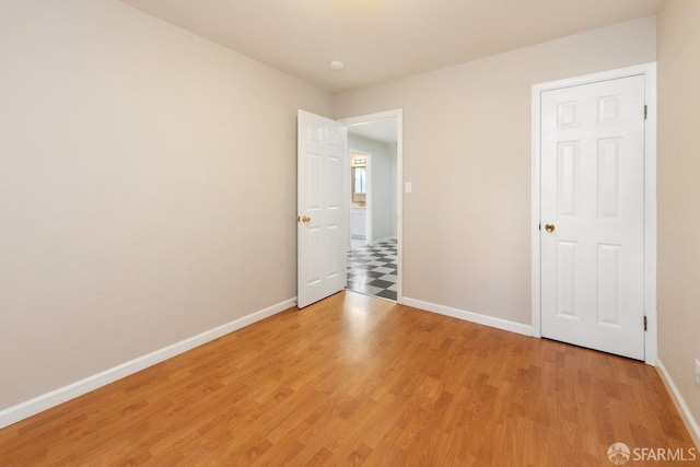 unfurnished room with light wood-style flooring and baseboards