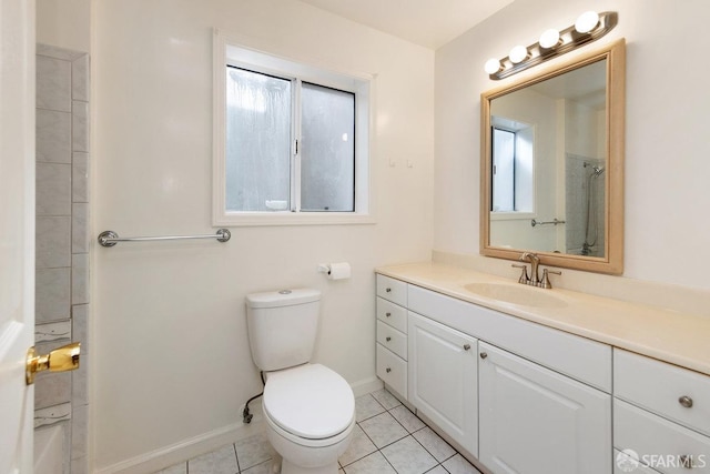 bathroom featuring toilet, vanity, baseboards, and tile patterned floors