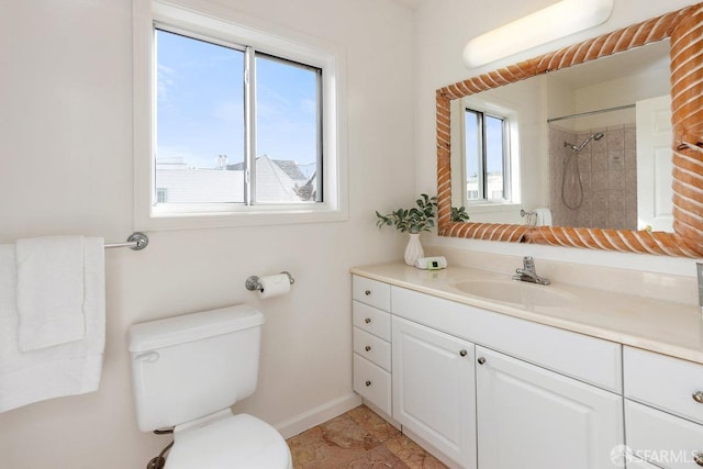 bathroom featuring toilet, plenty of natural light, walk in shower, and vanity